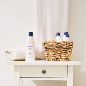 Noodle & Boo bottle beside baby bathtub demonstrating safe playful use