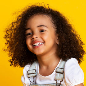 Not Your Mother's curl-defining cream in hand showing soft texture and frizz control