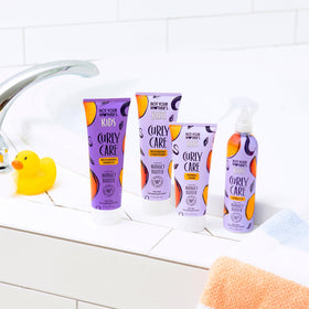 Not Your Mother's detangler spray being applied to curly hair for easy combing