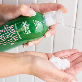 Not Your Mother's bottles beside hand to show 15.2 fl oz scale benefit