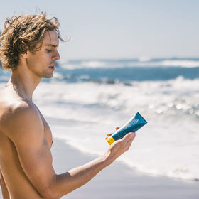 Oars + Alps sunscreen in use at beach showing water-resistant protection