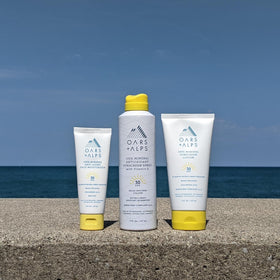 Oars + Alps 6oz bottle next to hand for scale displaying travel-friendly size and convenience