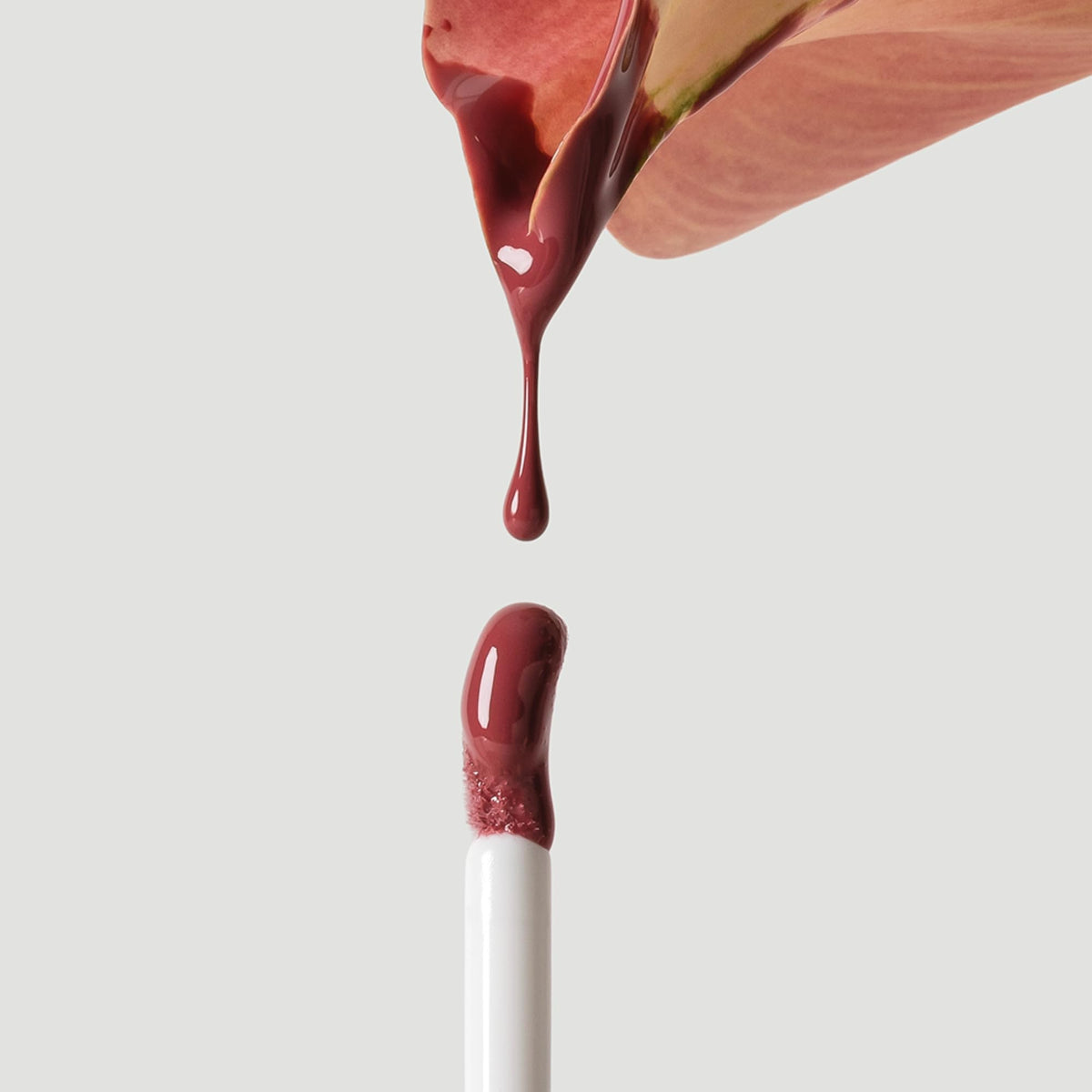 Ogee gloss layered over lipstick in lifestyle setting for enhanced shine
