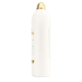 OGX 25.4 fl oz bottle next to hand showing product size