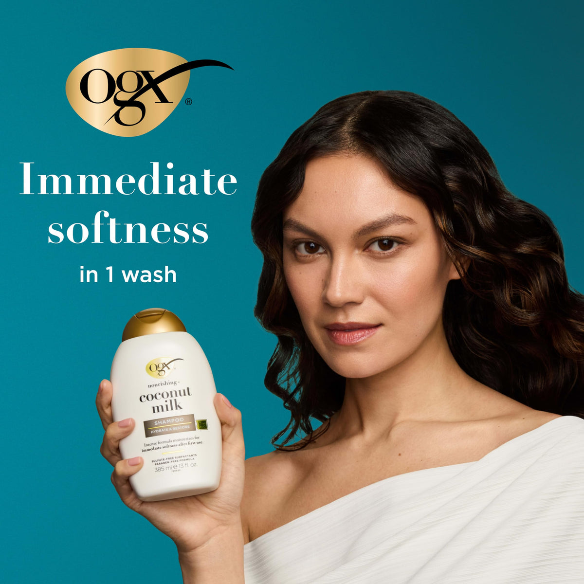 OGX held in hand for scale showing two 13 fl oz bottles and travel-friendly size