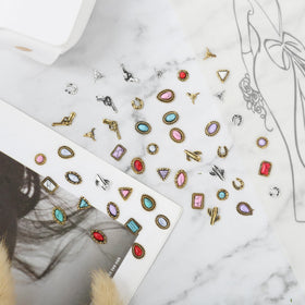 Ohmique charms on a fingertip showing size and practical scale for nail application