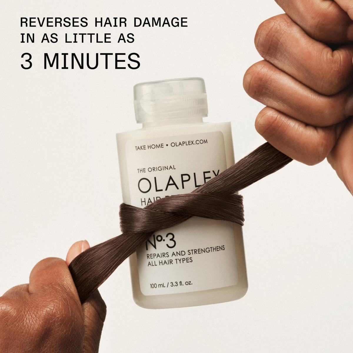Olaplex No.3 100ml bottle next to a hand for scale showing travel‑friendly size
