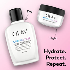 Olay firming night cream held in hand for size scale and easy-application benefit