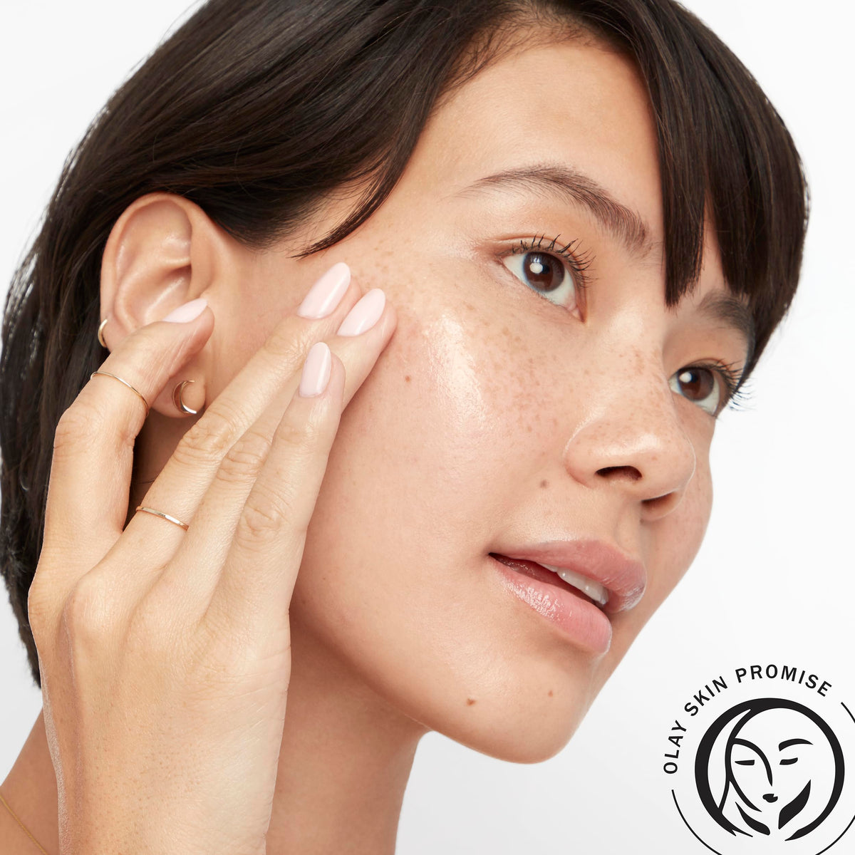 Hand pressing pump to dispense Olay serum demonstrating controlled application