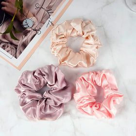 OLESILK scrunchie held in hand demonstrating compact size and gentle hold