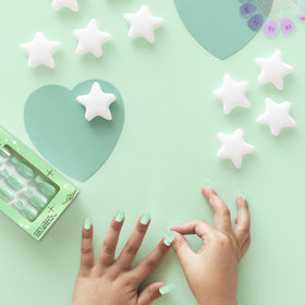 Child wearing Olive & June press-ons enjoying playtime with durable, stylish nails