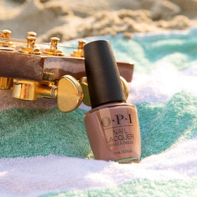 OPI bottle next to a coin for scale showing compact, travel-friendly size