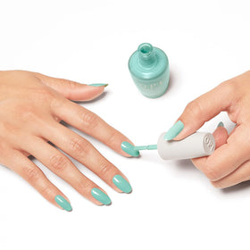 OPI manicured hands in beach outfit highlighting bold turquoise nails