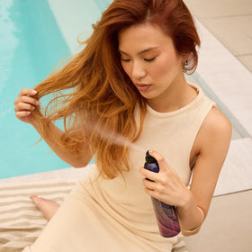 Oribe Après bottle in hand for scale demonstrating travel-friendly 8.5oz size