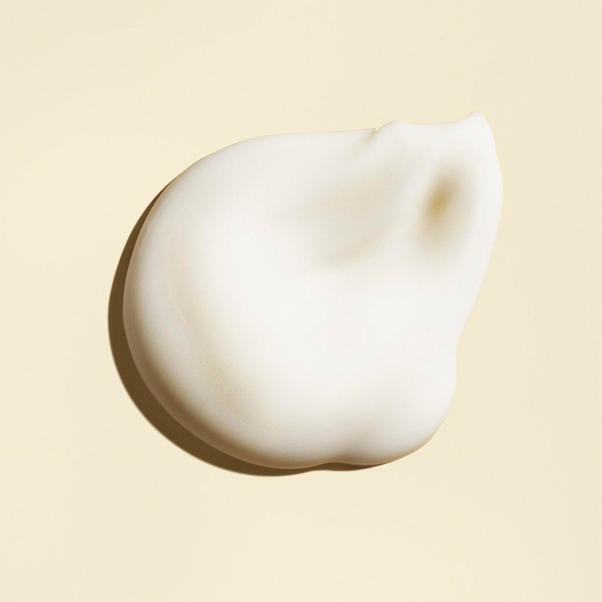 ORIBE dispensing cream onto fingers, demonstrating easy portion control