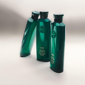 ORIBE bottle in hand for scale, demonstrates travel-friendly 5.9 fl oz size