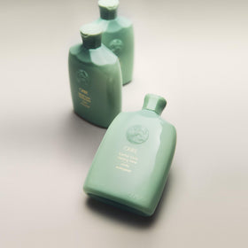 Oribe bottle staged in bathroom conveying refreshment and daily routine benefits