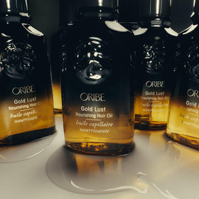 Applying Oribe Gold Lust on damp hair to detangle and protect before heat styling