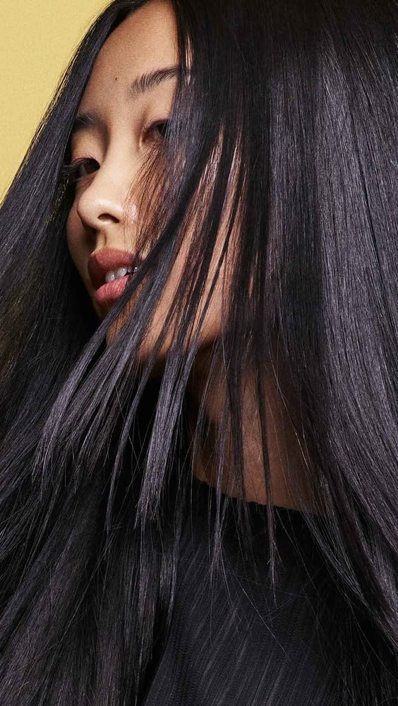 Oribe shampoo being massaged into wet hair showing breakage prevention benefit