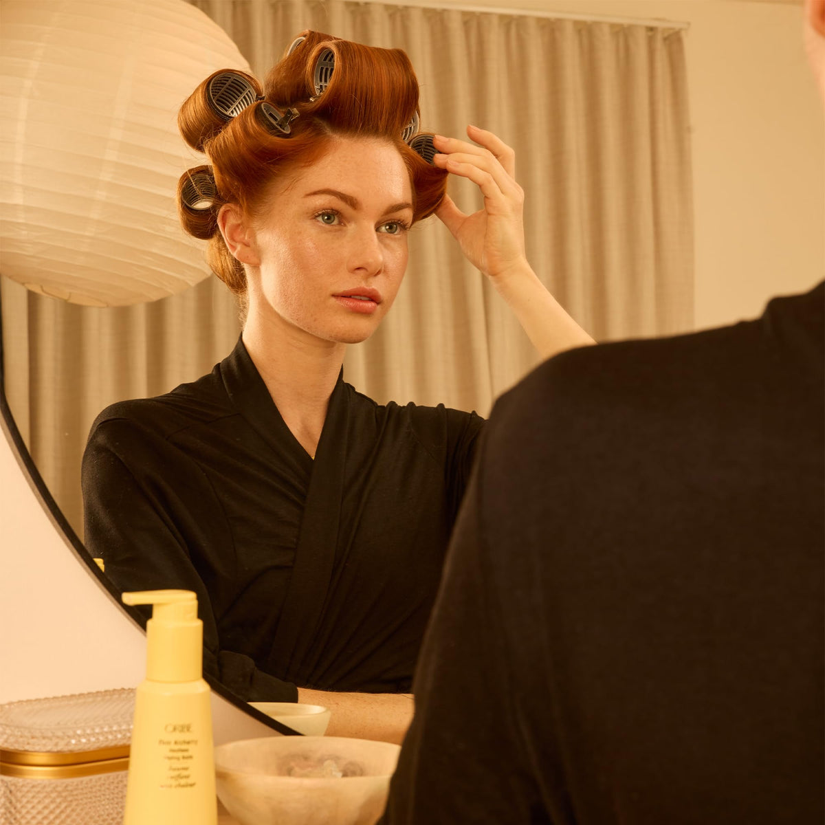 Oribe Hair Alchemy 5 oz bottle next to a ruler showing true size and travel-friendly benefit