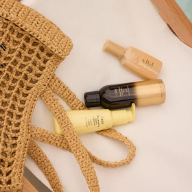 Oribe Impermeable on bathroom vanity with styling tools illustrating professional salon results