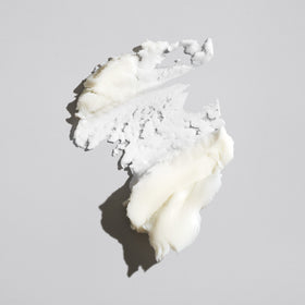 Oribe paste texture close-up on fingers demonstrating smooth spreadable consistency