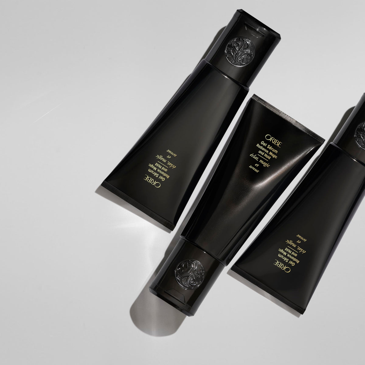 ORIBE bottle next to hand to show 5 oz size and travel-friendly benefit
