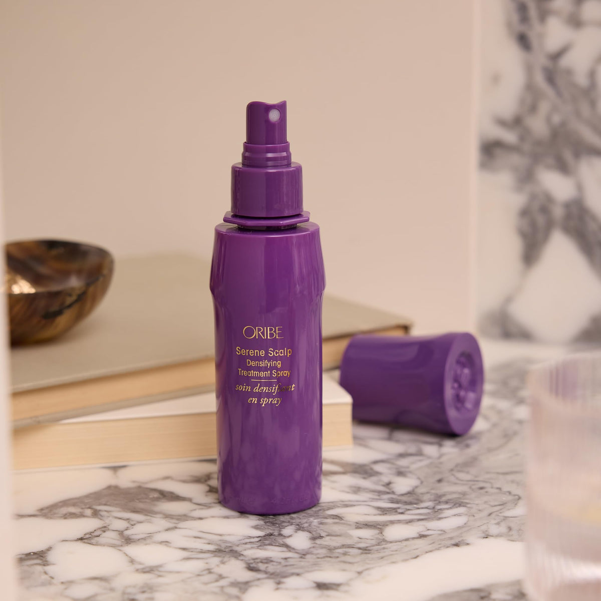 ORIBE product next to a ruler for scale, showing 4.2oz size and travel-friendly dimensions