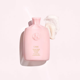 Oribe 8.5oz bottle in hand showing scale and travel-friendly size