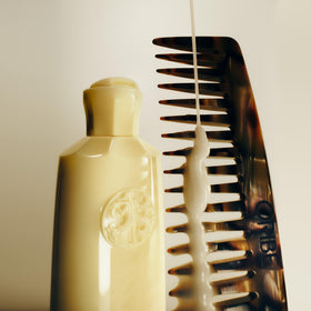 Oribe serum in bathroom lifestyle scene promoting easy daily styling benefit