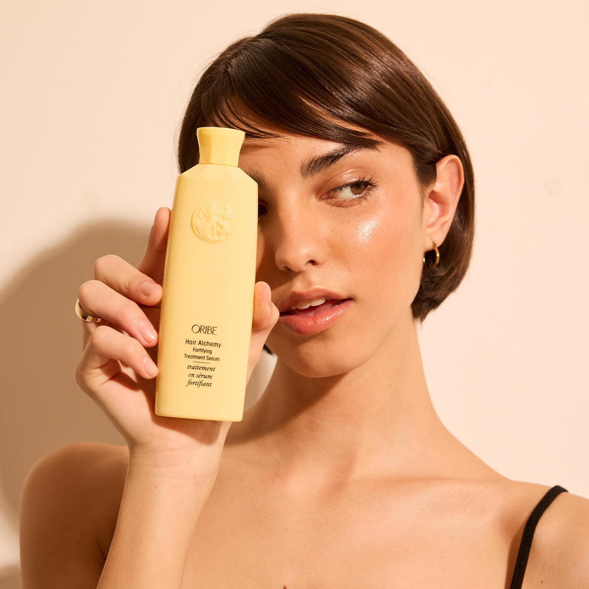 Oribe serum in hand scale comparison indicating generous 5.9 oz size benefit