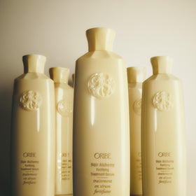 Oribe serum paired with shampoo and conditioner showing system-strengthening benefit