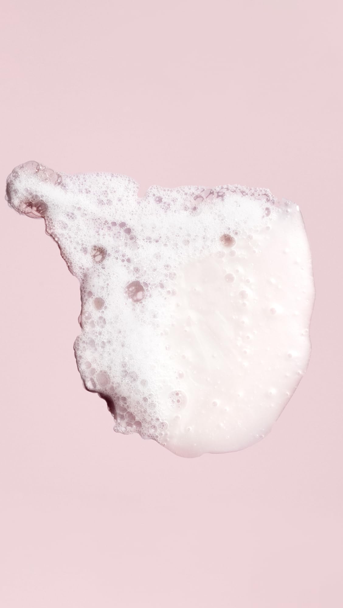 Oribe shampoo lather in hand demonstrating gentle foam and effective cleanse