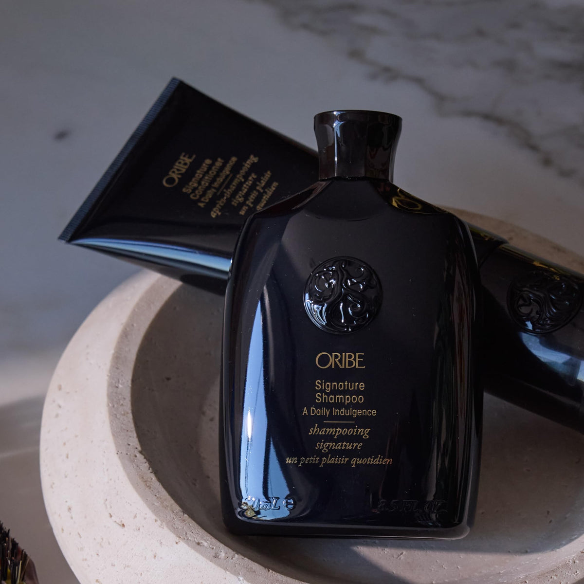 Wet hair being cleaned with Oribe signature shampoo demonstrating detangling benefit
