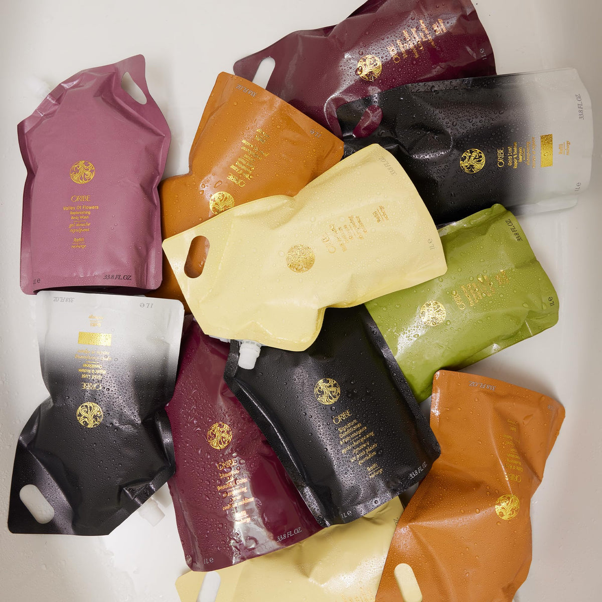 Oribe refill pouch staged in bathroom highlighting salon-quality convenience