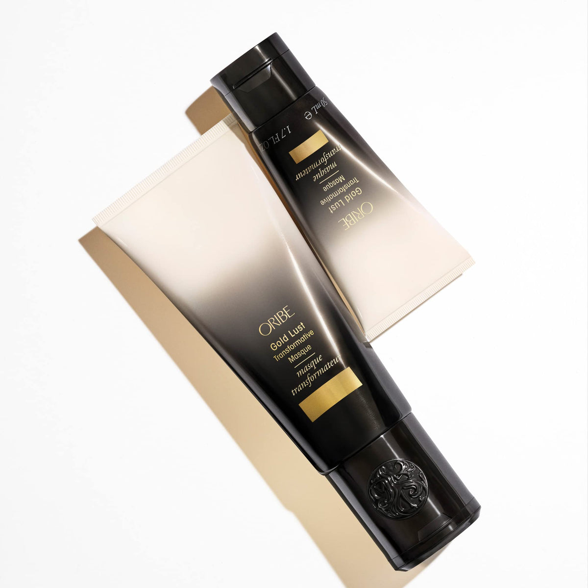 ORIBE mask held in hand to show 1.7 oz travel size for easy packing