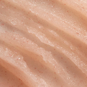 OSEA palm applying scrub to skin demonstrating gentle exfoliation and easy spreadability