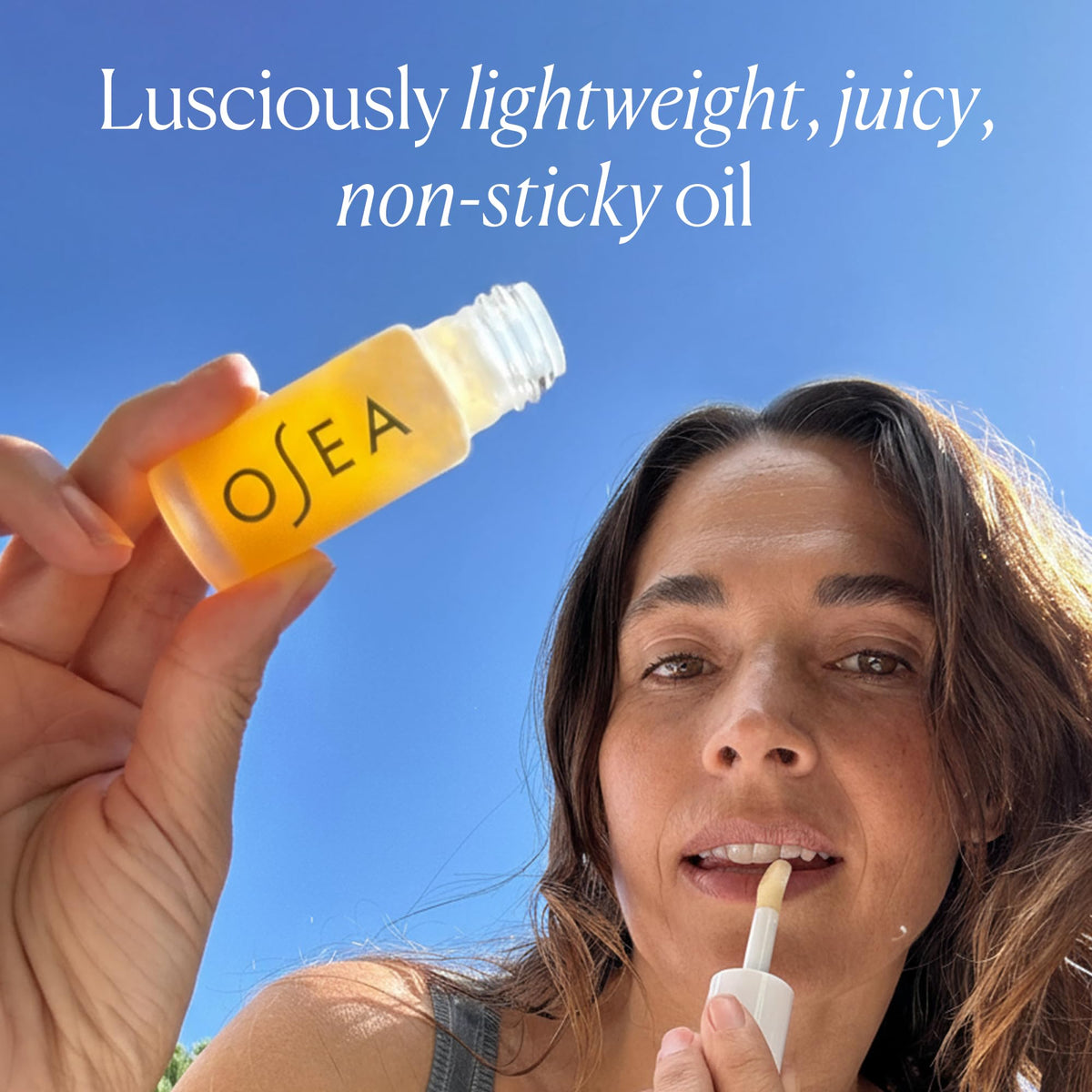 OSEA lip oil layered over lipstick demonstrating added shine and dimension benefit