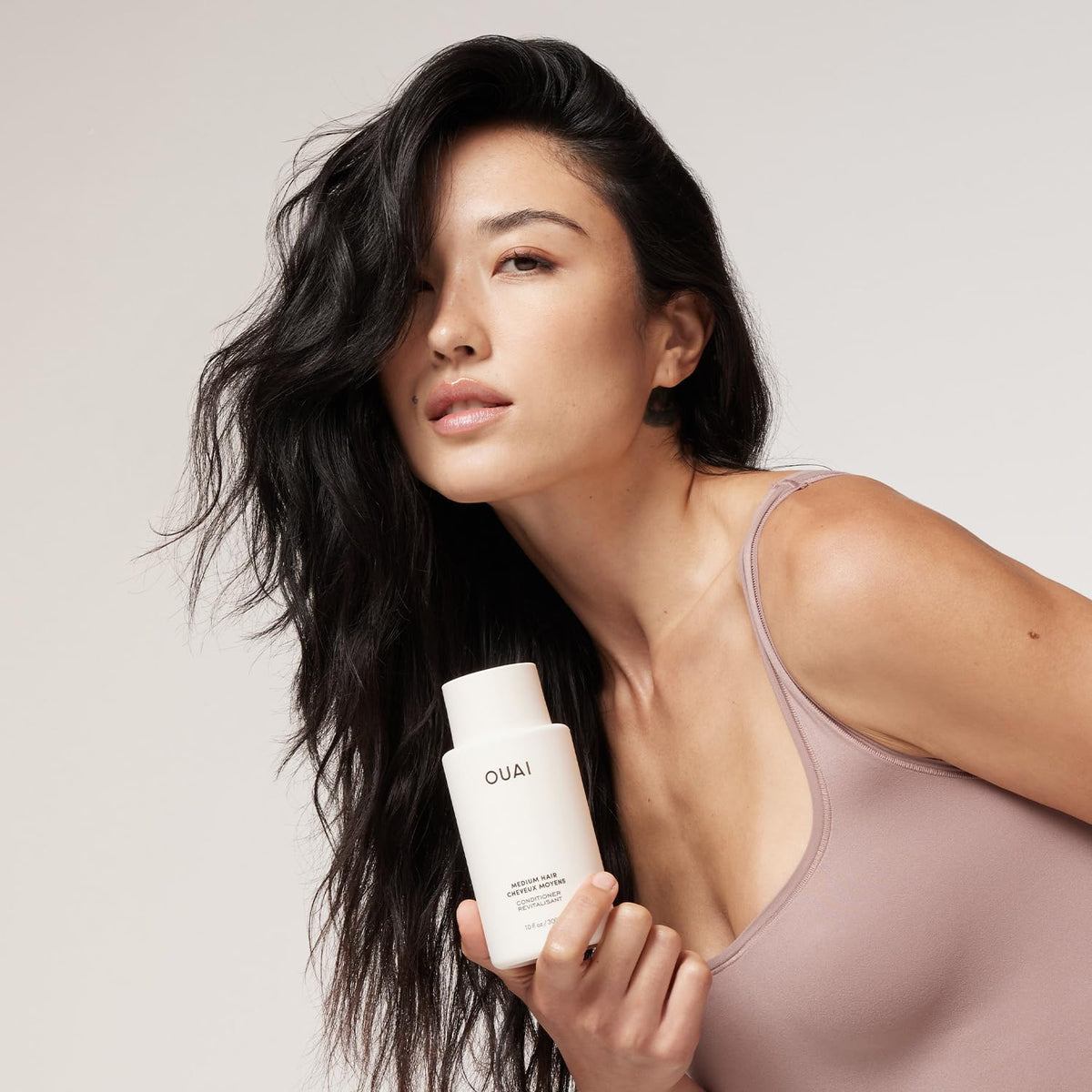 OUAI conditioner texture close-up highlighting creamy consistency for easy detangling