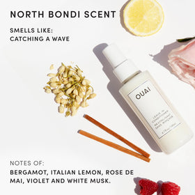 Hand holding OUAI bottle applying mist to mid-lengths for detangling