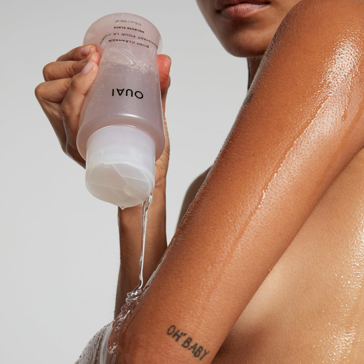 OUAI Melrose Place next to passport illustrating travel-sized convenience