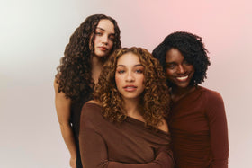 Ouidad scrunching curls to show how product reactivates curl pattern and reduces frizz
