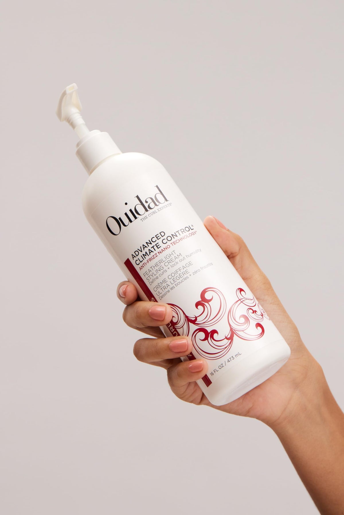Ouidad 16 fl oz jar next to hand to show actual product size