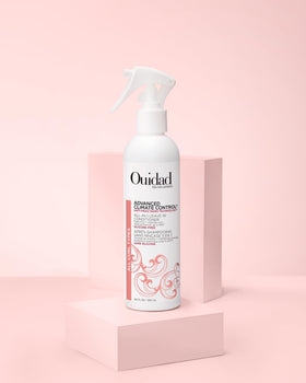 Ouidad bottle next to a water bottle to show size and portability benefit