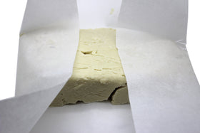 Our Earth's Secrets shea butter beside measuring cup illustrating 10-pound scale and batch efficiency