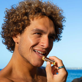 Panama Jack lip balm in use at the beach protecting lips from sun