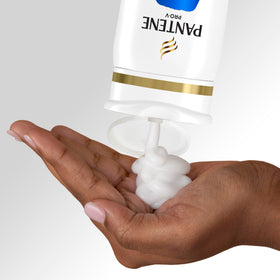 Pantene held in hand for scale illustrating travel‑friendly convenience