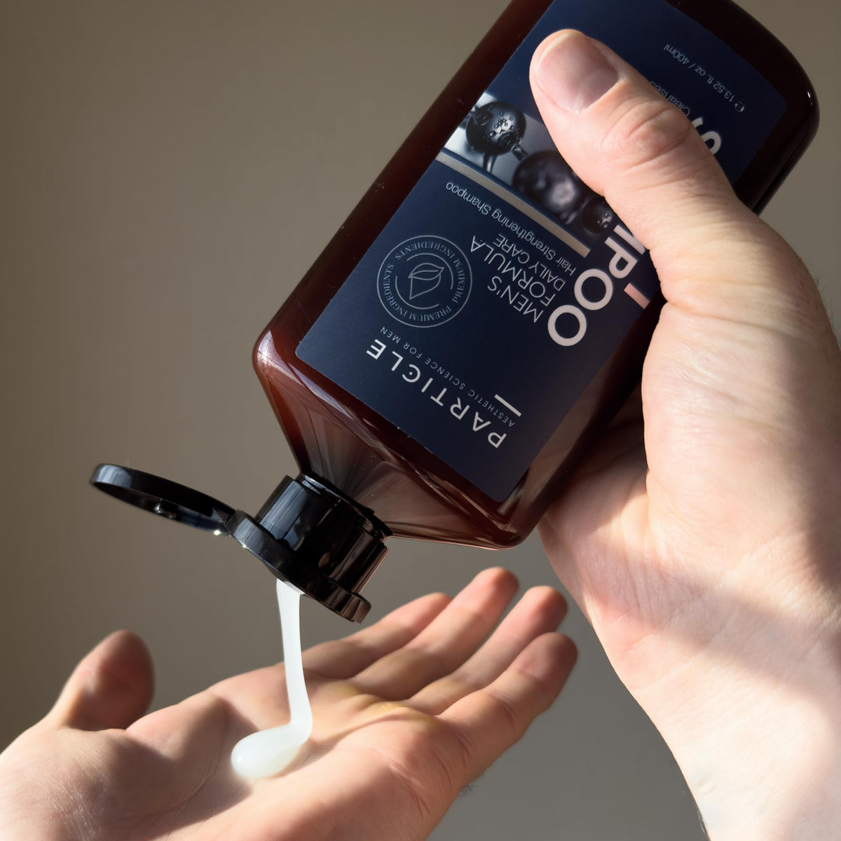 Particle shampoo bottle in shower demonstrating quick rinse and gym-ready use