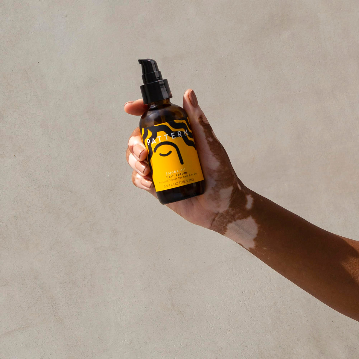 PATTERN smoothing serum into damp hair to seal moisture and manageability