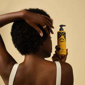 PATTERN Moisture Milk being applied in hands to smooth and hydrate curls